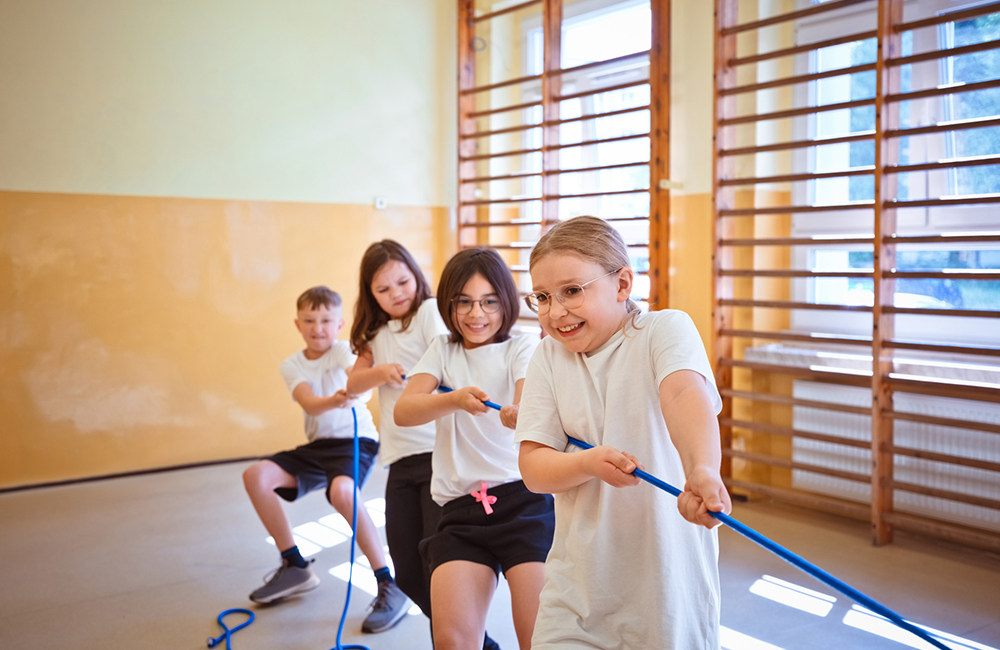 Four kids pulling a rope together