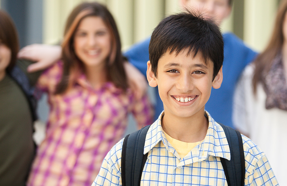 Smiling young school boy with backpack