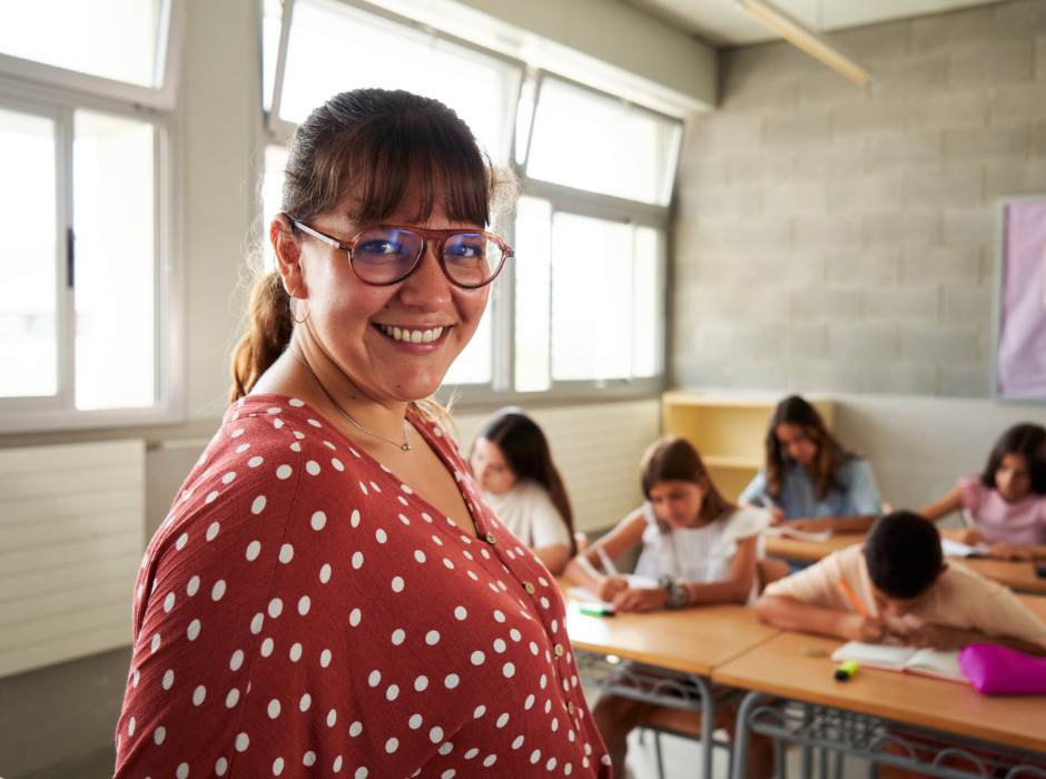 Smiling teacher with group of students in classroom