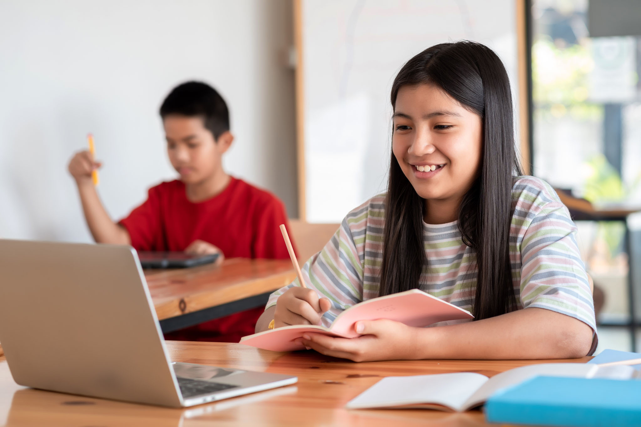 Two students in classroom doing schoolwork